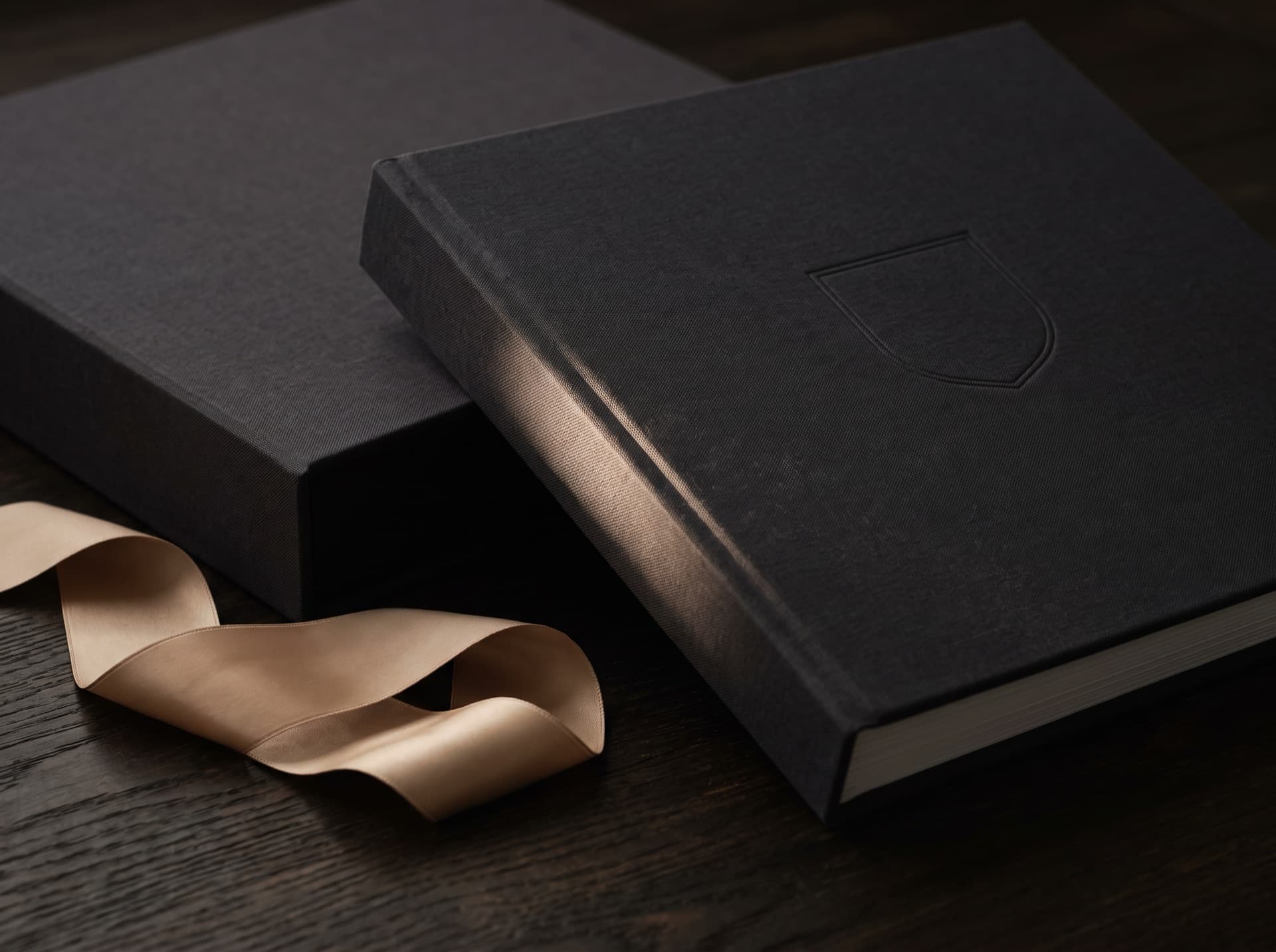 A closed custom linen boudoir album beside its keepsake presentation box